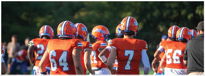 A group of football players on a field. Description generated by AI