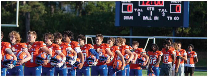 A group of football players on a field. Description generated by AI