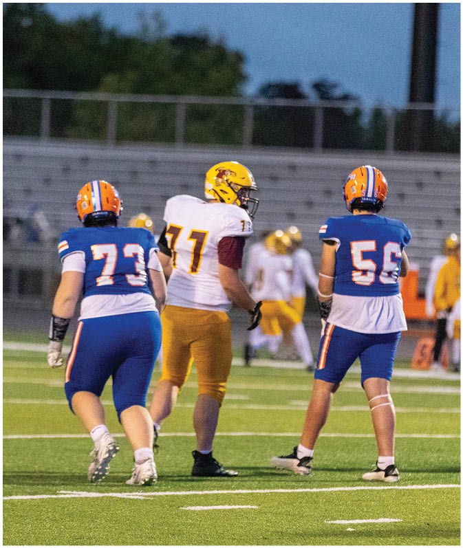 A group of football players wearing black and white uniforms. Description generated by AI