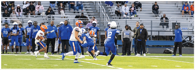 A group of football players on a field. Description generated by AI