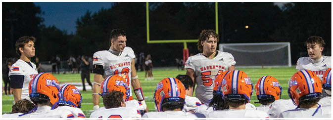 A group of football players on a field. Description generated by AI