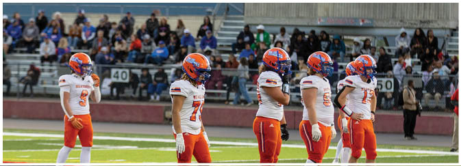 A group of football players on a field. Description generated by AI