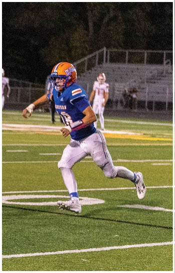 A football player running on the field. Description generated by AI