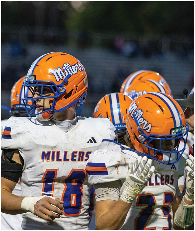 A group of football players wearing black and white uniforms. Description generated by AI