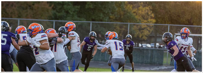 A group of football players on a field. Description generated by AI