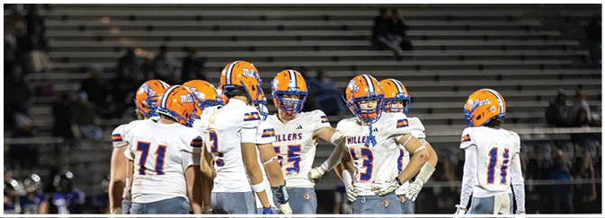 A group of football players on a field. Description generated by AI