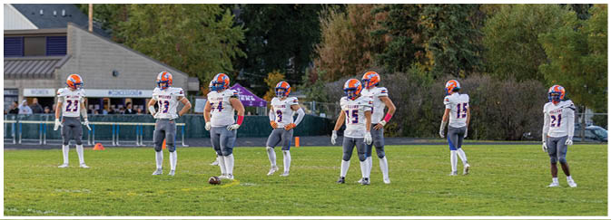 A group of football players on a field. Description generated by AI