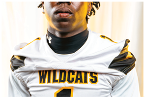 A person wearing a navy blue football jersey with white stripes on the shoulders and the words “COLLEGE PARK" above the number 11. Descripci n generada con IA