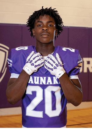 A young man wearing a white and black jersey with the number 14 on it. Description generated by AI