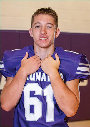 A young man wearing a white and black jersey with the number 14 on it. Description generated by AI