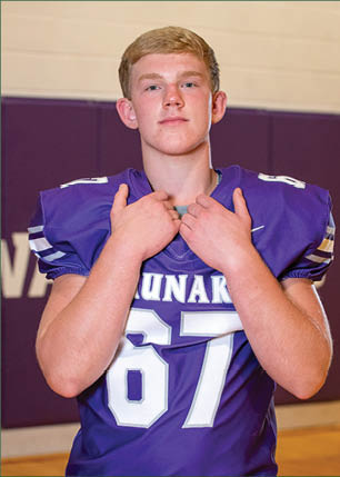 A young man wearing a white and black jersey with the number 14 on it. Description generated by AI
