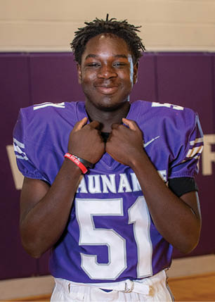 A young man wearing a white and black jersey with the number 14 on it. Description generated by AI