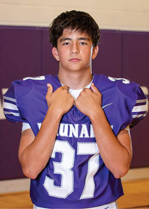 A young man wearing a white and black jersey with the number 14 on it. Description generated by AI