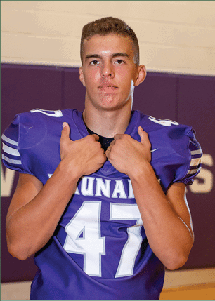 A young man wearing a white and black jersey with the number 14 on it. Description generated by AI
