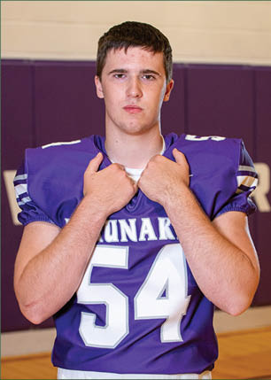 A young man wearing a white and black jersey with the number 14 on it. Description generated by AI
