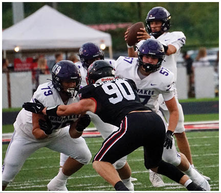 A group of football players huddled together on the field. Description generated by AI