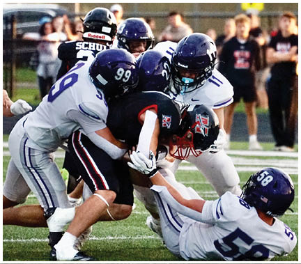 A group of football players huddled together on the field. Description generated by AI