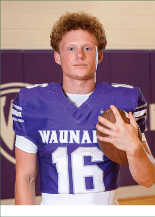 A young man wearing a white and black jersey with the number 14 on it. Description generated by AI