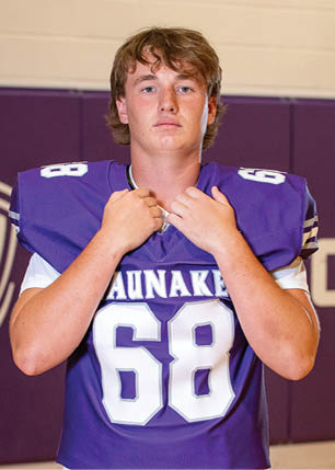 A young man wearing a white and black jersey with the number 14 on it. Description generated by AI