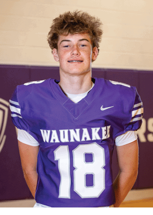 A young man wearing a white and black jersey with the number 14 on it. Description generated by AI