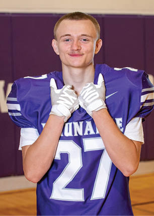 A young man wearing a white and black jersey with the number 14 on it. Description generated by AI