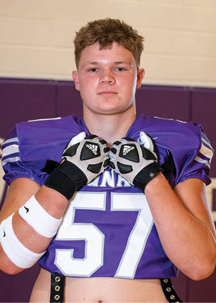 A young man wearing a white and black jersey with the number 14 on it. Description generated by AI
