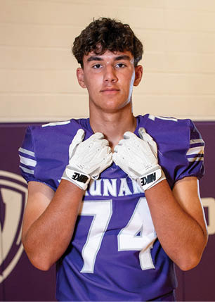 A young man wearing a white and black jersey with the number 14 on it. Description generated by AI