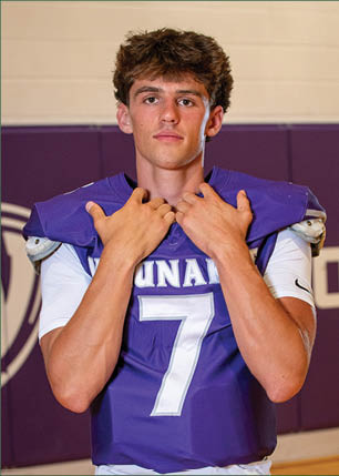 A young man wearing a white and black jersey with the number 14 on it. Description generated by AI