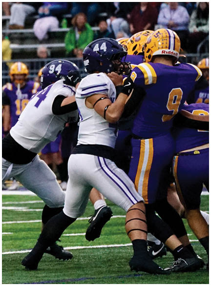A football player wearing a blue and white uniform. Description generated by AI