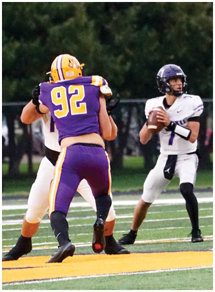 A football player wearing a blue and white uniform. Description generated by AI