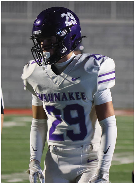 A football player wearing a blue and white uniform. Description generated by AI