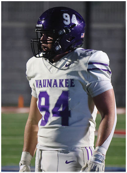 A football player wearing a blue and white uniform. Description generated by AI