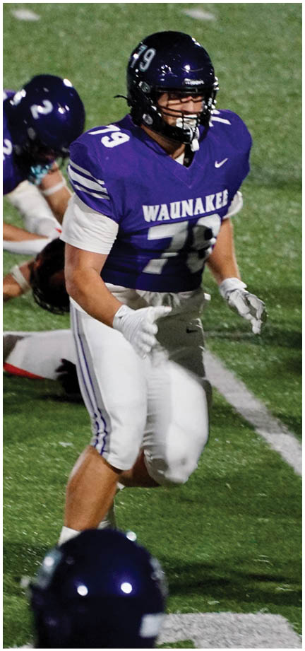 A football player wearing a blue and white uniform. Description generated by AI