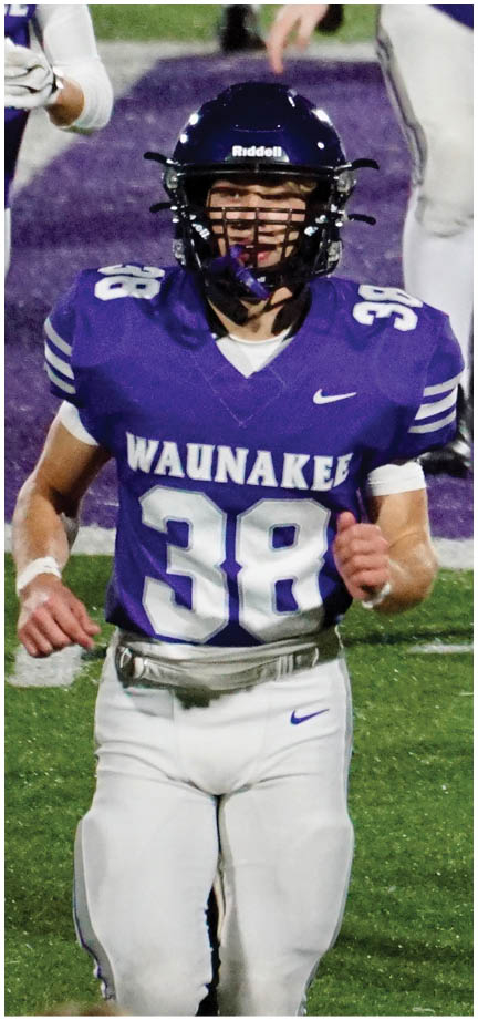A football player wearing a blue and white uniform. Description generated by AI