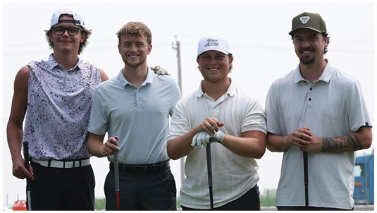 Three adults wearing polo shirts stand side by side on a golf course holding golf clubs and smiling. Description generated by AI