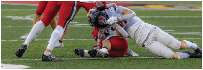 A football game is taking place on a field with players wearing blue and white uniforms. Description generated by AI