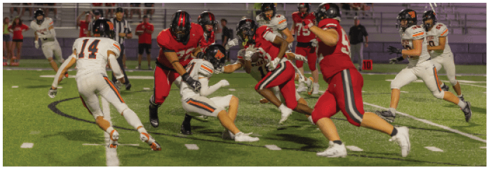 A football game is taking place on a field with players wearing blue and white uniforms. Description generated by AI