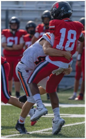 Two football players wearing blue and white uniforms. Description generated by AI