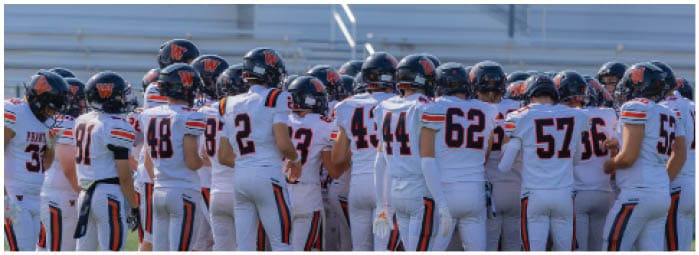 A group of football players on a field. Description generated by AI