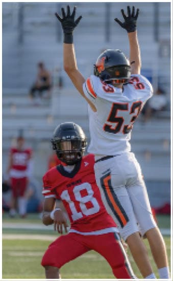 Two football players wearing blue and white uniforms. Description generated by AI