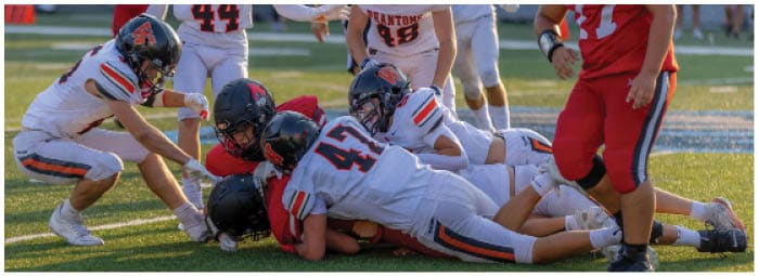 A group of football players on a field. Description generated by AI