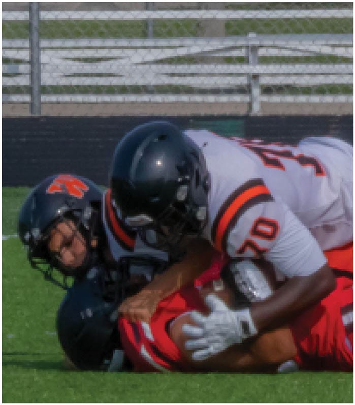 A group of football players on a field. Description generated by AI