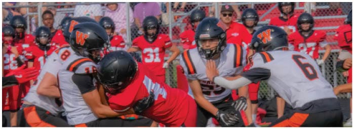 A group of football players on a field. Description generated by AI