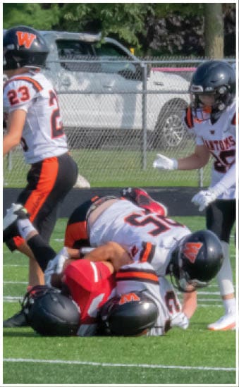 Two football players wearing blue and white uniforms. Description generated by AI