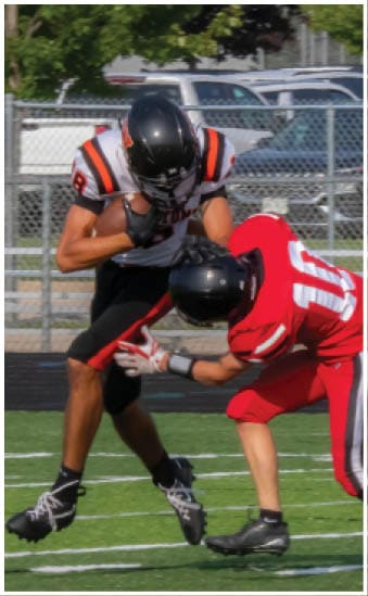 Two football players wearing blue and white uniforms. Description generated by AI