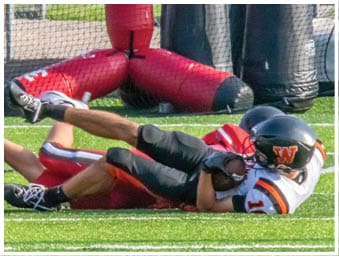 A football player running on the field. Description generated by AI