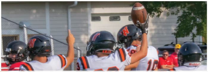A football game is taking place on a field with players wearing blue and white uniforms. Description generated by AI