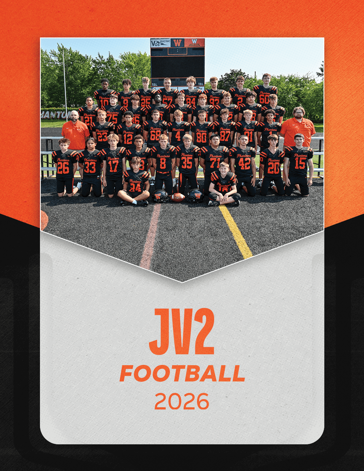 A group of people wearing black and orange football uniforms pose together on a field with coaches in orange shirts behind them and the text JV2 Football 2026 below. Description generated by AI