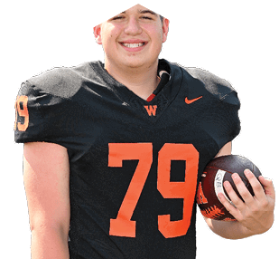 Person wearing a black football jersey with the number 79 in orange, smiling and holding a football. Description generated by AI