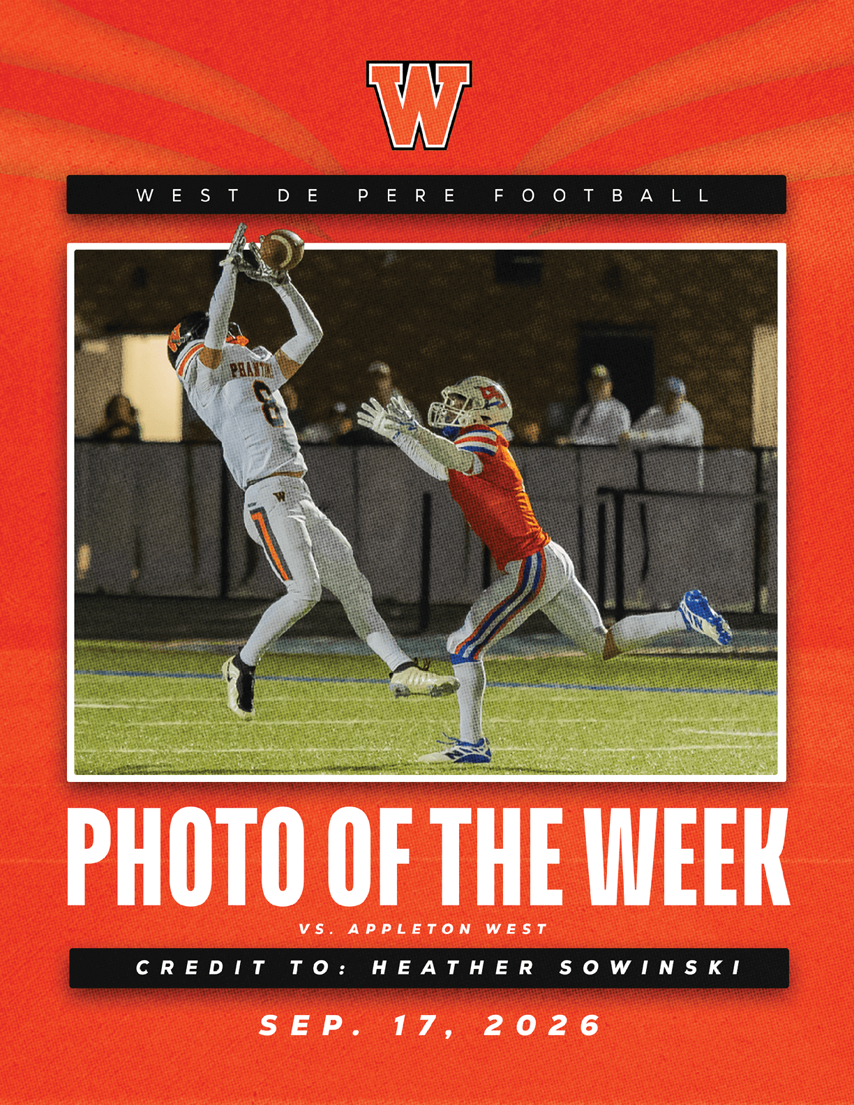 A football player in white uniform leaps to catch a ball while a player in red uniform reaches out to defend on a field during a night game. Description generated by AI